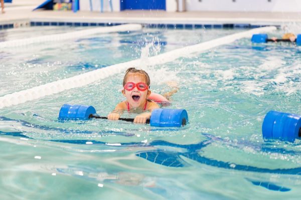 little-girl-swimming-in-a-pool-with-red-goggles