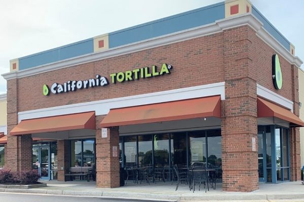 california-tortilla-sign-on-brick-building-with-chairs-and-tables-patio