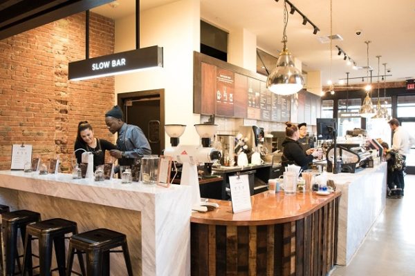 coffee-bar-with-employees-wooden-counter-and-stools