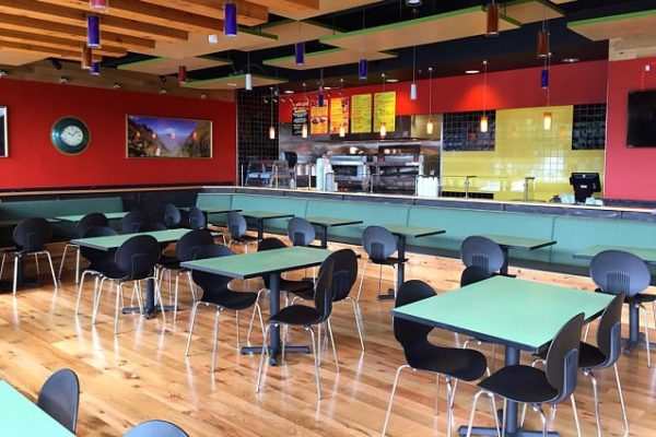 green-table-black-chairs-wooden-floors-restaurant