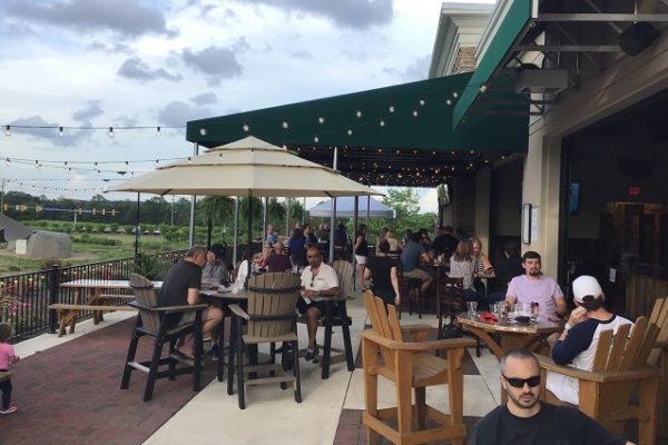 people-dining-on-restaurant-patio-green-roof-and-garden