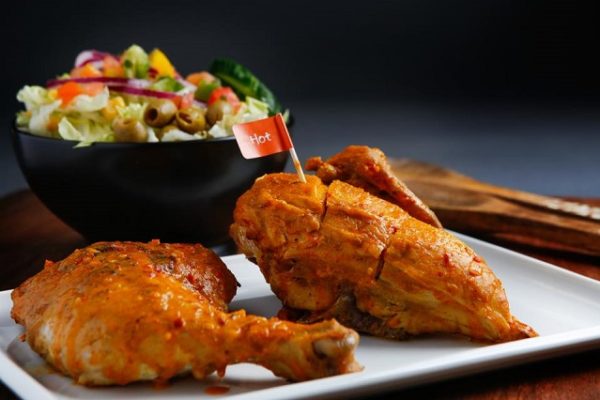 peri-peri-chicken-on-white-plate-and-bowl-of-salad