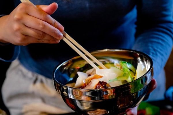 person-with-a-bowl-of-food-chopsticks-and-blue-shirt