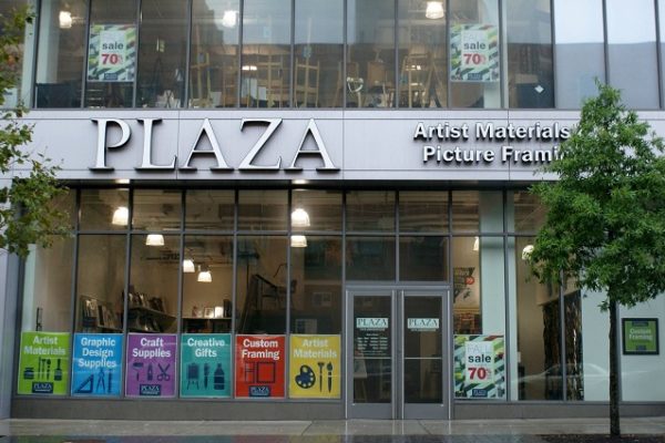 plaza-sign-outside-glass-door-building-with-trees