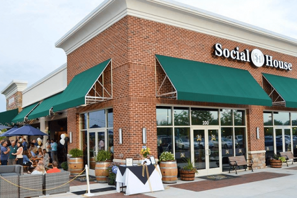 social-house-sign-on-brick-wall-people-on-patio