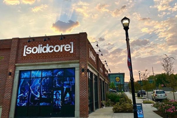 solidcore-sign-on-brick-building-blue-skies-with-clouds