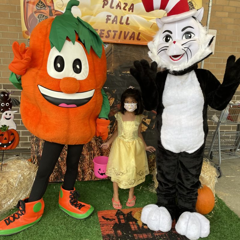 Kid with dressed up characters the cat in the hat and pumpkin