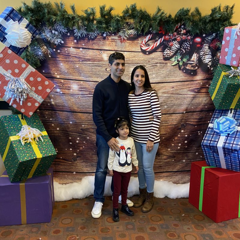 Couple and child posing with christmas background