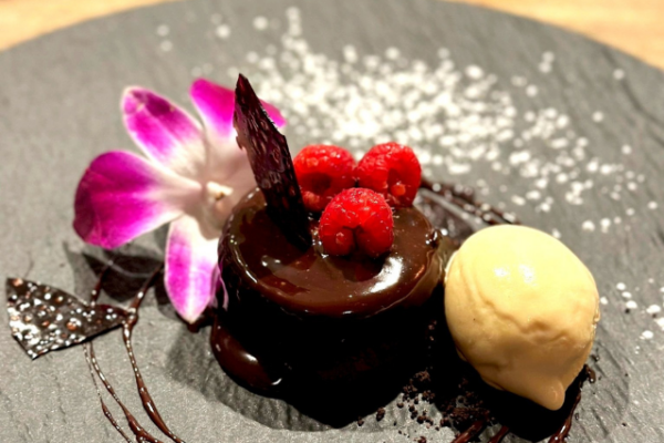 clarity_retailer_3 flan covered in chocolate garnished with a magenta tropical flower