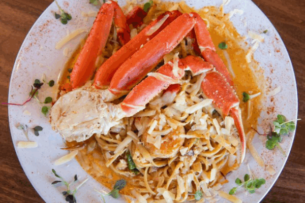 miss_toyas_1 loaded seafood pasta on a white plate with leaf details